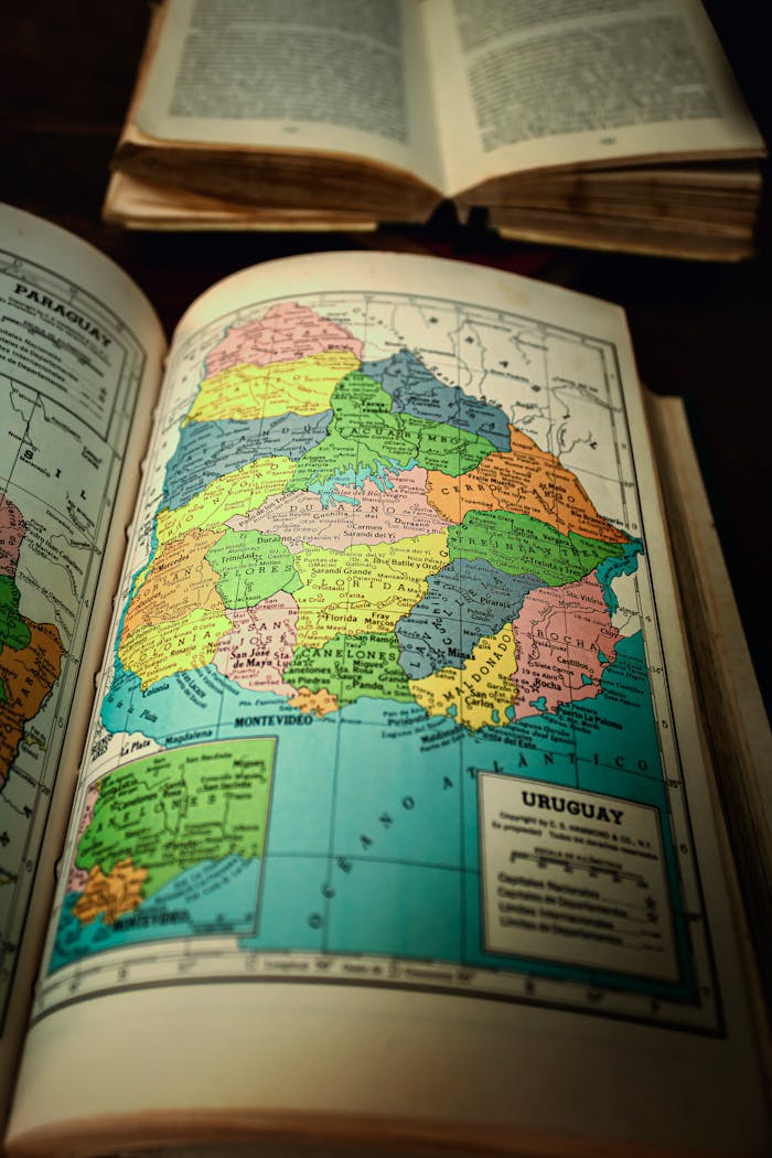 Explore the colorful vintage map of Uruguay in an old atlas book, highlighting South American cartography.