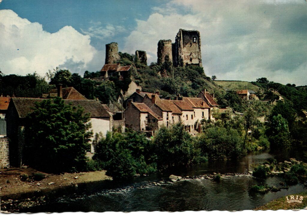 Carte postale ancienne colorisée de Hérisson montrant les ruines du château au-dessus du village et de la rivière.
