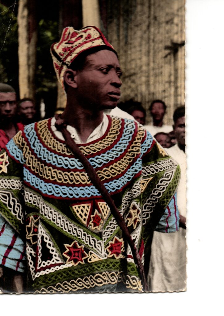 Carte postale ancienne du Cameroun représentant un notable bamiléké en tenue traditionnelle brodée