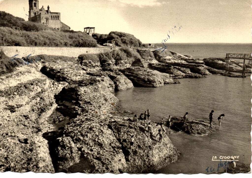 Carte postale ancienne du Concié à Saint-Palais-sur-Mer montrant la côte rocheuse, les baigneurs et un édifice sur le promontoire